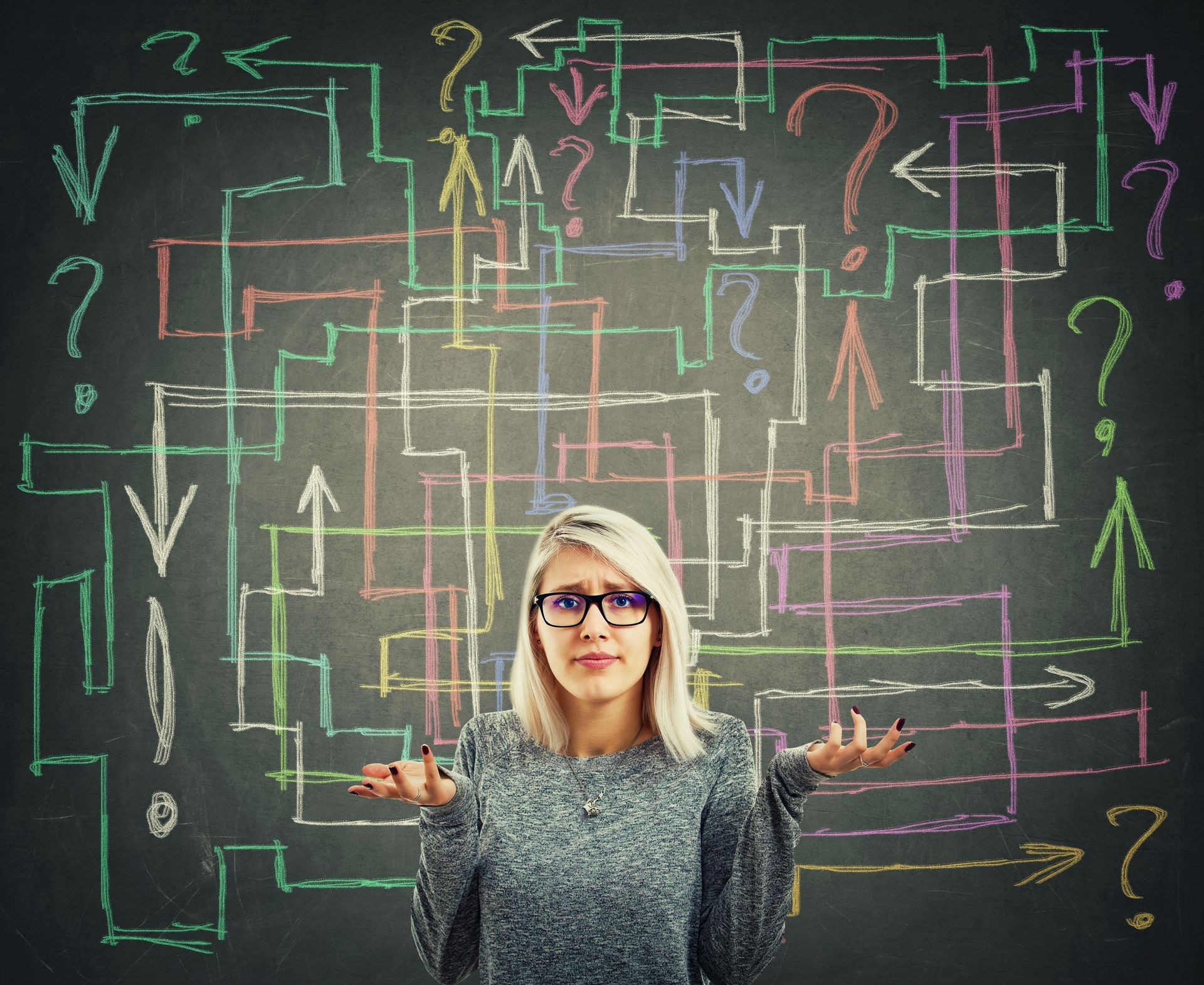 Confused young woman in front of blackboard with different colorful arrows try to solve a questions maze and find the answer. Problem analysis solution concept.